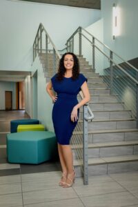 realtor in blue dress by staircase
